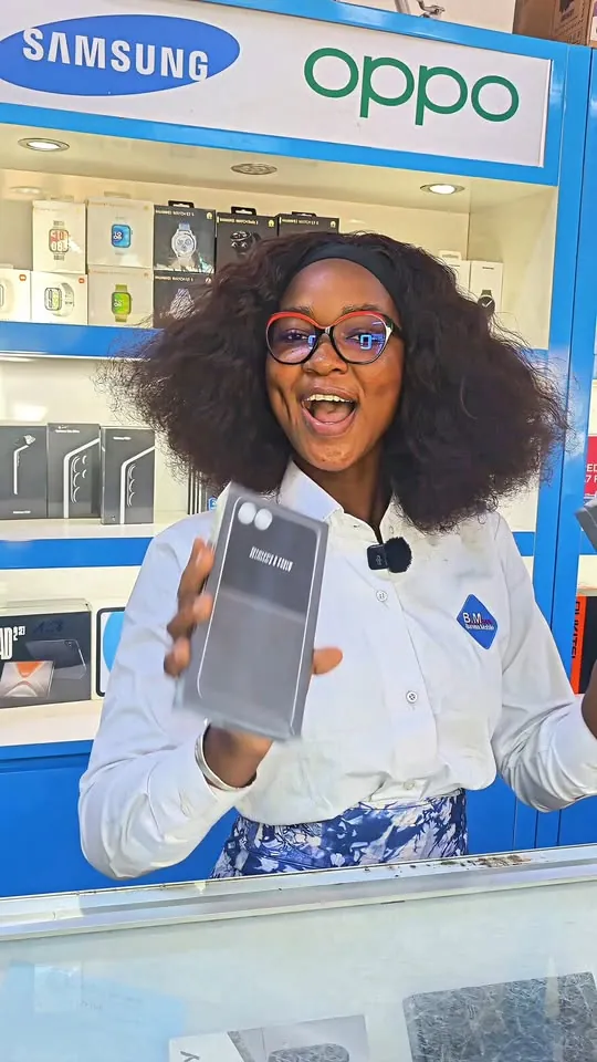 Une vendeuse présente un smartphone en boutique
